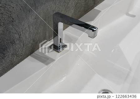 This contemporary restroom features a spacious design with a clean sink, dual faucets, and frosted glass details, perfect for urban living This contemporary restroom features a spacious design with a clean sink, dual faucets, and frosted glass details, perfect for urban living 122663436