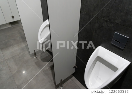 This restroom features a contemporary design with a focus on cleanliness, showcasing a stylish urinal and hygiene-friendly aesthetics This restroom features a contemporary design with a focus on cleanliness, showcasing a stylish urinal and hygiene-friendly aesthetics 122663555