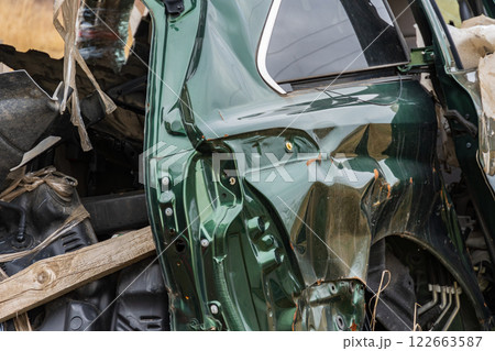 A wrecked car lies in a rural location, showcasing extensive damage to the side panel and highlighting transportation dangers and insurance concerns A wrecked car lies in a rural location, showcasing extensive damage to the side panel and highlighting transportation dangers and insurance concerns 122663587