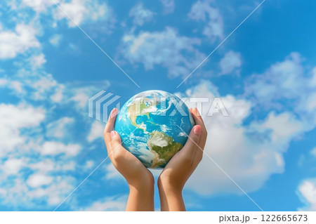 Hands holding a small globe against a bright blue sky with scattered clouds, symbolizing care, responsibility, and hope for the planet Hands holding a small globe against a bright blue sky with scattered clouds, symbolizing care, responsibility, and hope for the planet 122665673
