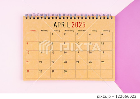 April 2025 desk calendar made from brown paper page on purple background. 122666022