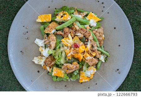 Homemade sliced chicken and fried egg, cherry tomatoes with salad featuring variety fresh green vegetables. 122666793