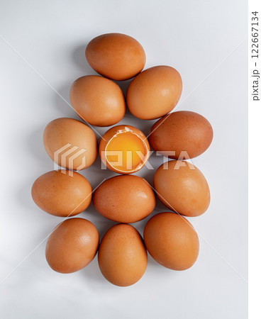Top view of Egg yolk in Broken raw chicken eggshell in the among of Fresh chicken egg on white background. 122667134