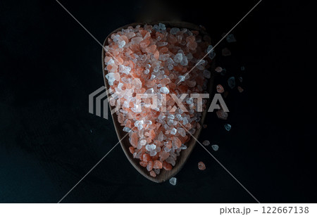 Top view of Pink Himalayan Salt with Bright colors textured surface on Wooden scoop with the dark background. Top view of Pink Himalayan Salt with Bright colors textured surface on Wooden scoop with the dark background. 122667138