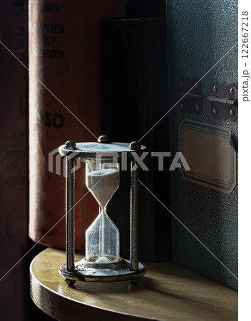 The morning sun shines hits of Silver hourglass or Sandglass and Vintage wooden box on wooden round table, The morning sun shines hits of Silver hourglass or Sandglass and Vintage wooden box on wooden round table, 122667218