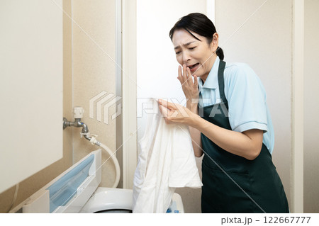 洗濯したTシャツの汚れが落ちなくて悩む女性 122667777