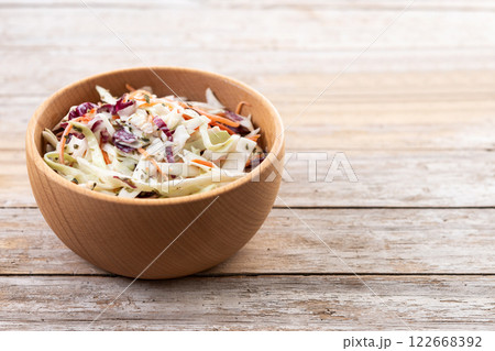 Coleslaw salad in wooden bowl on wooden table 122668392