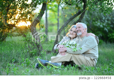 Portrait of senior couple sitting on the grass in the park Portrait of senior couple sitting on the grass in the park 122668458