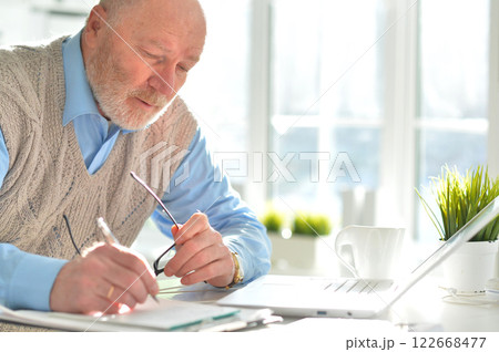 Portrait of an elderly man using a laptop in an office 122668477