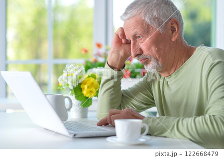 Portrait of senior man with laptop at home 122668479