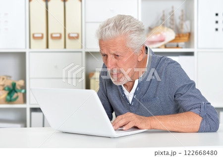 Portrait of senior man with laptop at home Portrait of senior man with laptop at home 122668480