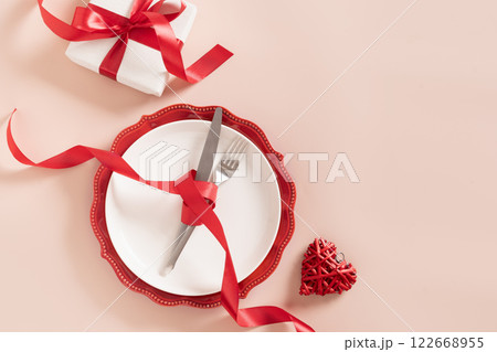 Valentines day table place setting with romantic gift on pink background. View from above. Festive dinner. Copy space. Valentines day table place setting with romantic gift on pink background. View from above. Festive dinner. Copy space. 122668955