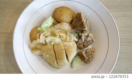 Savor Pempek, savory fishcakes from Palembang, Indonesia, served with sweet and sour kuah cuko sauce. A culinary blend of fish and tapioca, enriched with unique flavors. 122670351