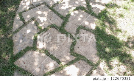 Geometric shape stepping stone pathway under the shadow laying on the ground at garden or park. 122670381