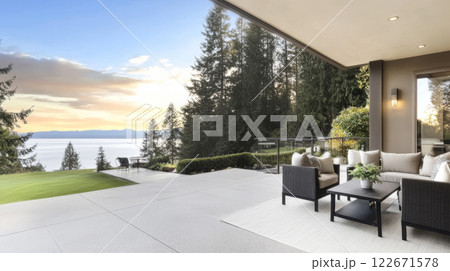 Cozy outdoor seating area overlooking a serene lake at sunset with lush trees in the background 122671578