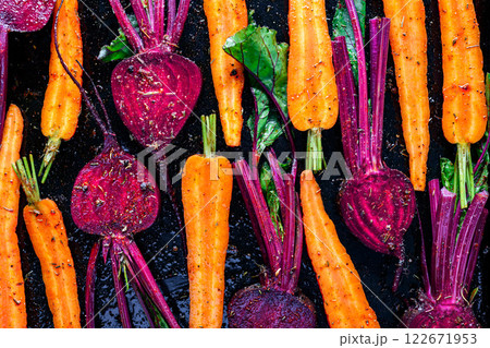 Juicy beet and carrot slices before baking in the baking oven Juicy beet and carrot slices before baking in the baking oven 122671953