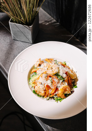 Delicious shrimp pasta dish served in a stylish restaurant setting with fresh ingredients Delicious shrimp pasta dish served in a stylish restaurant setting with fresh ingredients 122672686
