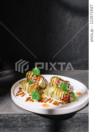 Freshly prepared cabbage rolls topped with savory ingredients served on a clean white plate Freshly prepared cabbage rolls topped with savory ingredients served on a clean white plate 122672687