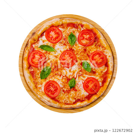 Freshly baked pizza topped with tomatoes and basil on a wooden serving board Freshly baked pizza topped with tomatoes and basil on a wooden serving board 122672902