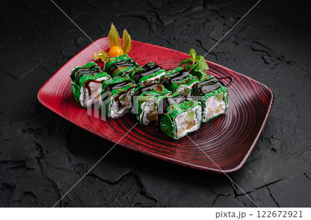 Colorful sushi rolls presented on an elegant plate with artistic garnishes in a modern dining setting 122672921