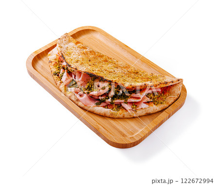 Savory ham and cheese crepe served on a wooden tray with herbs and spices for added flavor 122672994
