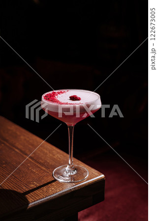 Sipping a vibrant raspberry cocktail in an ambient bar setting at night Sipping a vibrant raspberry cocktail in an ambient bar setting at night 122673005