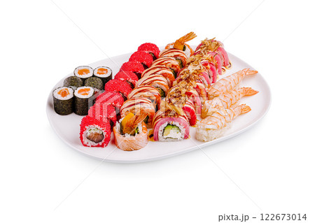 Colorful assortment of sushi rolls arranged on a white platter in a casual dining setting 122673014
