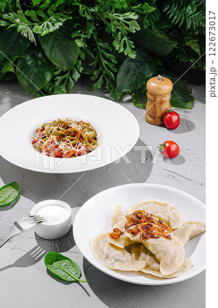 Delicious plate of fresh pasta and dumplings served with herbs and vegetables in a bright setting 122673017