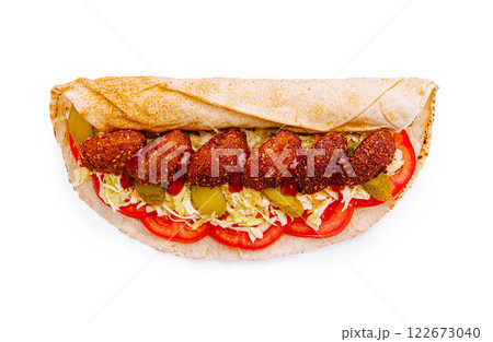 Delicious falafel wrap filled with fresh tomatoes, lettuce, and pickles ready to enjoy on a sunny day Delicious falafel wrap filled with fresh tomatoes, lettuce, and pickles ready to enjoy on a sunny day 122673040