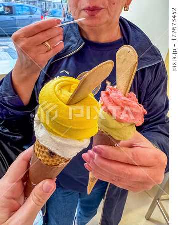 Colorful gelato cones with fruit flavors enjoyed in a cozy ice cream shop. High quality photo Colorful gelato cones with fruit flavors enjoyed in a cozy ice cream shop. High quality photo 122673452