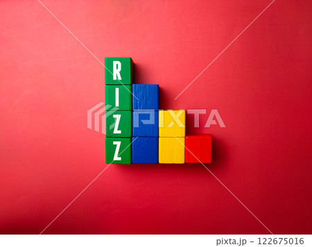 Colored wooden block with word RIZZ. A slang word that means a person's charisma or attractiveness in the context of attracting a partner romantically. 122675016
