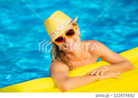 Happy young woman having fun in swimming pool on summer vacation Happy young woman having fun in swimming pool on summer vacation 122675682