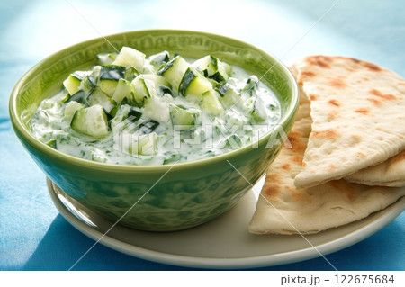 Traditional Greek Tzatziki dip sauce made with cucumber sour cream. Yogurt sauce with dill, lemon juice, olive oil. Served with toasted Za'atar Pita bread. Top view. Tarator, cacik or tartar. Traditional Greek Tzatziki dip sauce made with cucumber sour cream. Yogurt sauce with dill, lemon juice, olive oil. Served with toasted Za'atar Pita bread. Top view. Tarator, cacik or tartar. 122675684