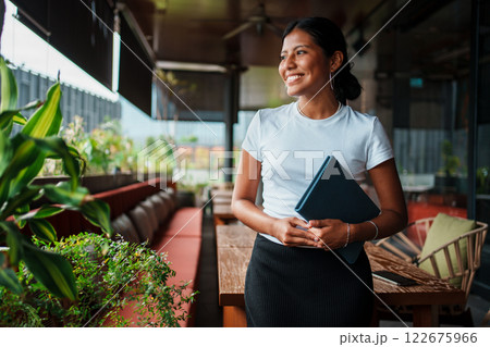 Confident Businesswoman Smiling in Modern Caf Setting Confident Businesswoman Smiling in Modern Caf Setting 122675966