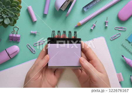 Women's hands hold empty purple stickers. Stationery background, pastel colors. A place for your text. 122676167