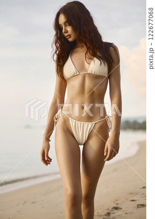 Beautiful body woman on the beach. Sexy girl in Bikini at sunset time 122677068