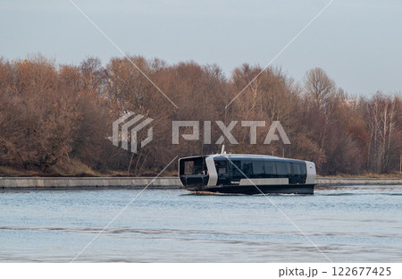 Electric river tram on the Moskva River at sunset on an autumn evening. Electric river tram on the Moskva River at sunset on an autumn evening. 122677425