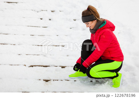 Woman wearing sportswear tying shoes 122678196