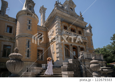 A woman is standing on a set of stairs in front of a large building 122679383