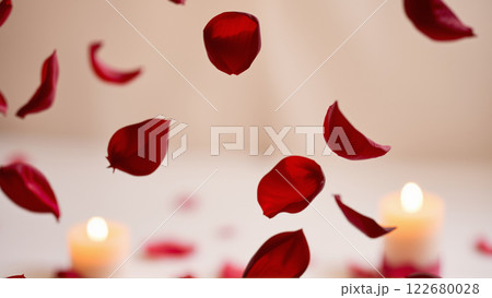Rose petals falling down against the background of burning candles 122680028