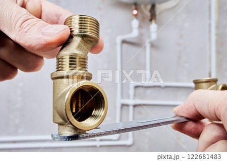 Close-up of threaded brass connector, was named dog legs reducer, used in plumbing systems. 122681483