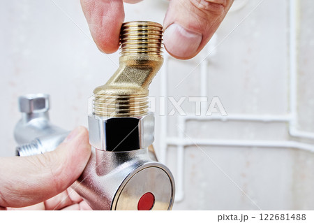 Male tap eccentric reducer is being screwed into plumbing valve with precise alignment. 122681488
