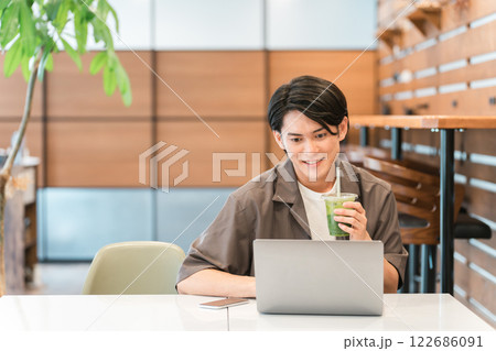 カフェ・家でノートパソコンを使う若い男性（テレワーク・リモートワーク） 122686091