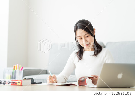 リスキリングのため参考書を確認する30代女性 リスキリングのため参考書を確認する30代女性 122686103