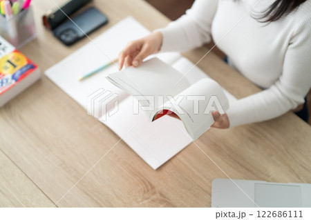 リスキリングのため参考書を確認する女性　顔無し 122686111