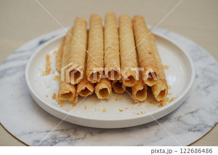 Pile of Cigarette Russe rolled biscuits on white plate 122686486