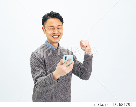 スマホを見ながらガッツポーズするミドルエイジ男性 スマホを見ながらガッツポーズするミドルエイジ男性 122686790