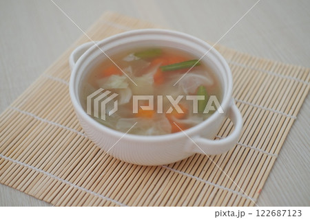 A bowl of fresh soup on a table 122687123