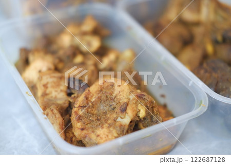Three plastic containers filled with spiced chicken Three plastic containers filled with spiced chicken 122687128