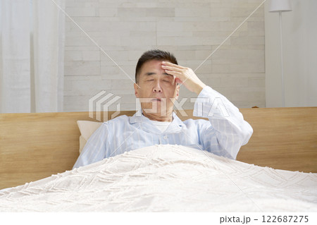 頭痛がするパジャマを着た中年の男性 頭痛がするパジャマを着た中年の男性 122687275